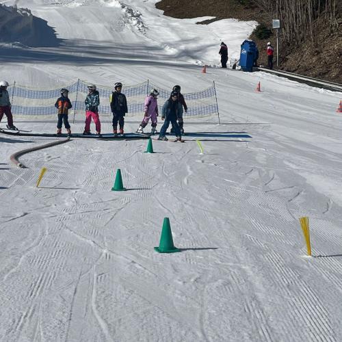 Kinder fahren Slalom mit Hütchen